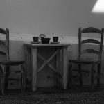 Two chairs at a small table set for two by Emiliano Cicero
